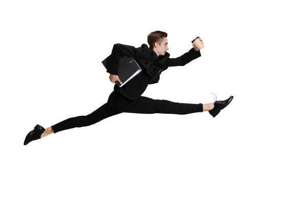 Hombre joven en traje de negocios negro saltando aislado sobre fondo blanco. Arte, movimiento, acción, flexibilidad, concepto de inspiración. — Foto de Stock