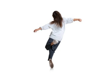 Arkadan bak. Sıradan giyinen bir kadın beyaz arka planda tek başına koşuyor. Sanat, hareket, eylem, esneklik, ilham kavramı.