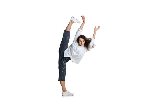 Flexibele vrouw in casual kleding staande in een touw geïsoleerd op witte achtergrond. Kunst, beweging, actie, flexibiliteit, inspiratie. — Stockfoto