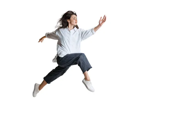 Jonge vrouw in casual kleding beweegt dynamisch geïsoleerd op een witte achtergrond. Kunst, beweging, actie, flexibiliteit, inspiratie. — Stockfoto