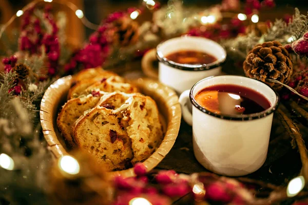 Two cups of winter mulled wine with spices and orange slices on festive decorated table with Christmas bake. Still life with traditional drink — Stock Photo, Image