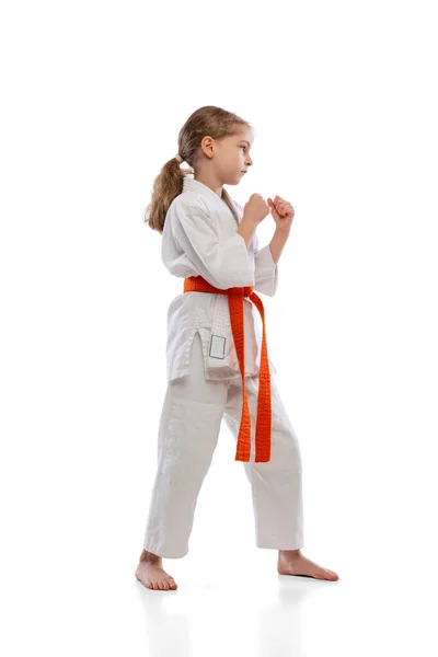 Stúdió felvétel a kislány, fiatal karate edzés egyedül elszigetelt fehér háttér. A sport, az oktatás és a készségek fogalma — Stock Fotó