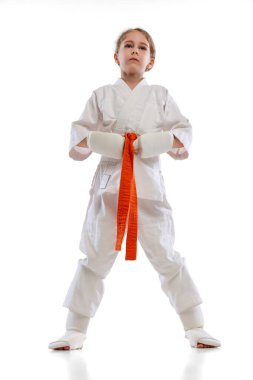 Küçük kızın tam boy portresi, beyaz arka planda izole edilmiş genç karate pozu. Spor, eğitim, beceri kavramı