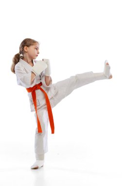 Küçük bir kızın portresi, beyaz arka planda tek başına genç bir karate eğitimi. Spor, eğitim, beceri kavramı