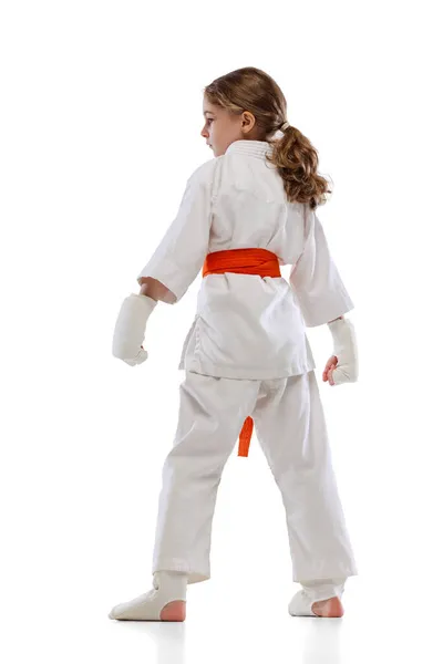 Baksidan av liten flicka, ung karate poserar isolerad över vit bakgrund. Begreppet idrott, utbildning, färdigheter — Stockfoto