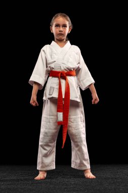 Beyaz arka planda izole edilmiş küçük sportif kız eğitim karatesinin tam boy portresi. Spor, eğitim, beceri kavramı