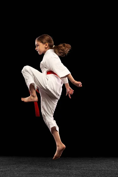 Karate, taekwondo flicka med gult bälte isolerad på mörk bakgrund i neon ljus. Begreppet idrott, utbildning, färdigheter — Stockfoto