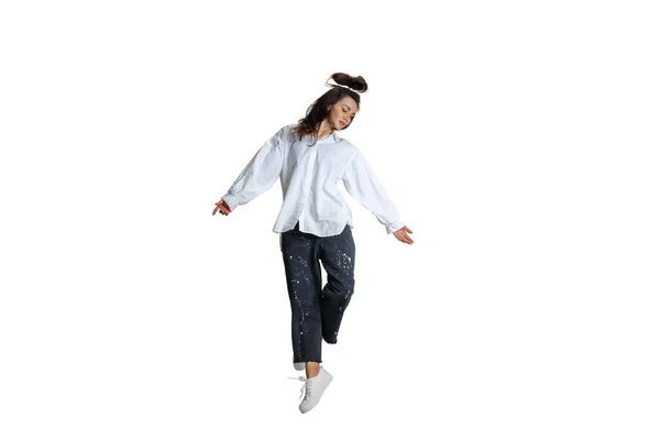 En vacker känslosam flicka i casual wear rör sig dynamiskt isolerad på vit bakgrund. Konst, rörelse, handling, flexibilitet, inspirationskoncept. — Stockfoto