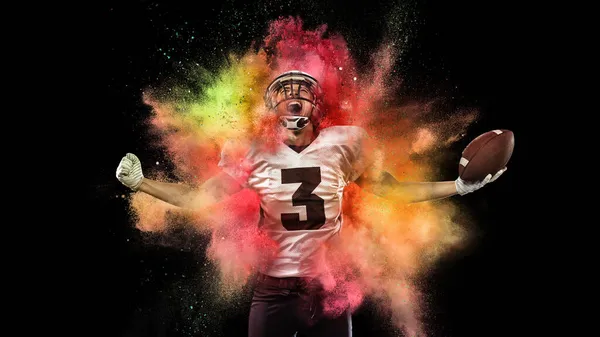 Colagem com jovem desportista, jogador de futebol gritando como vencedor na explosão de pó de néon colorido isolado no fundo escuro — Fotografia de Stock