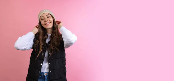 Gelukkig, vrolijk jong mooi meisje in gebreide hoed geïsoleerd op roze studio achtergrond in neon licht. Concept van emoties, gezichtsuitdrukking — Stockfoto