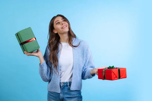 Aufgeregt junge schöne Mädchen mit Geschenkboxen isoliert auf blauem Studiohintergrund. Konzept der Emotionen, Frohe Weihnachten — Stockfoto