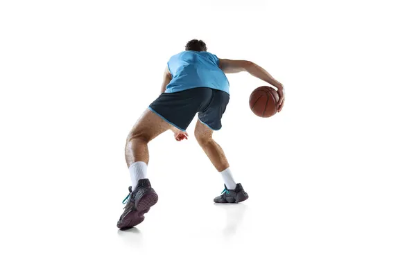 白いスタジオの背景に隔離された青いスポーツ制服のトレーニングでプロバスケットボール選手のバックビュー. — ストック写真