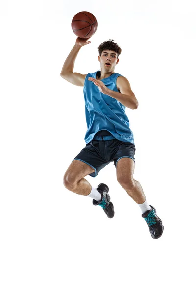 Full length portrait of basketball player training isolated on white studio background. Tall muscular athlete jumping with ball. — Stock Photo, Image