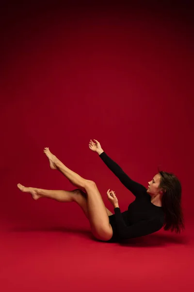 Jovem bela bailarina desprezo feminino, bailarina em performance de arte isolada no fundo vermelho escuro. Arte, beleza, conceito de inspiração. — Fotografia de Stock