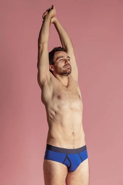 Meia-comprimento retrato de jovem bonito barbudo sem camisa homem de pé sozinho isolado no fundo do estúdio rosa. — Fotografia de Stock