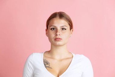 Pembe stüdyo arka planında izole edilmiş genç kızıl saçlı kızın yakın çekim görüntüsü..