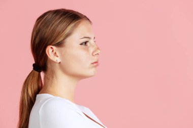 Pembe stüdyo arka planında izole edilmiş genç kızıl saçlı kızın yakın plan görüntüsü..