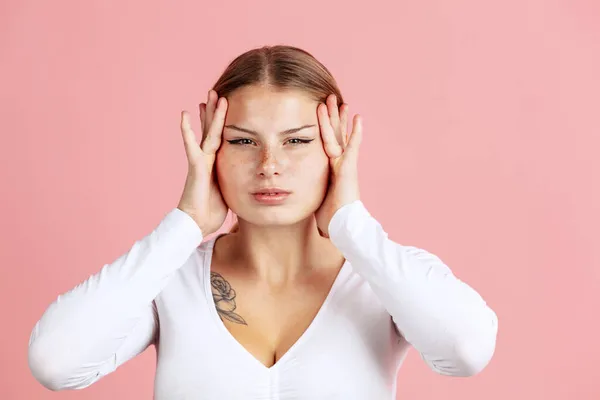 Half-length portrait of young beautiful girl isolated on pink color studio background. Concept of human emotions — Stock Photo, Image