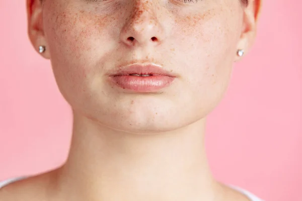 Zugeschnittene Bild von Nahaufnahme junge Mädchen Gesicht mit niedlichen Sommersprossen isoliert über rosa Studiohintergrund. Gesichtsausdruck — Stockfoto