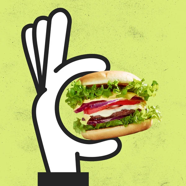 Сучасне мистецтво колаж намальованої мультиплікаційної руки тримає великий смачний бургер ізольований на зеленому тлі. Скубічна їжа — стокове фото