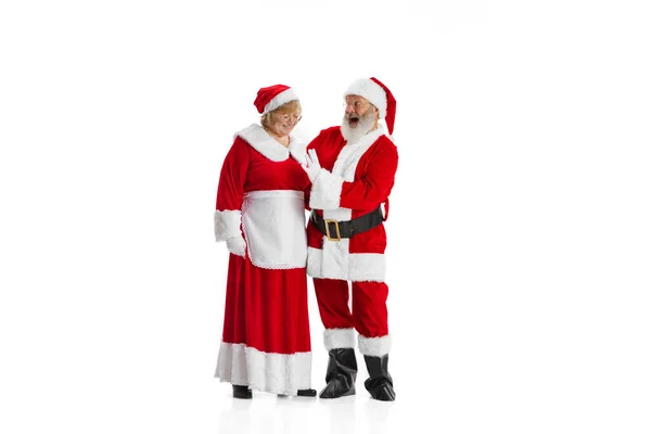 Emotional senior man and woman, Santa Claus and his wife in traditional costume isolated on white background. Christmas, New Year 2022 — Stock Photo, Image