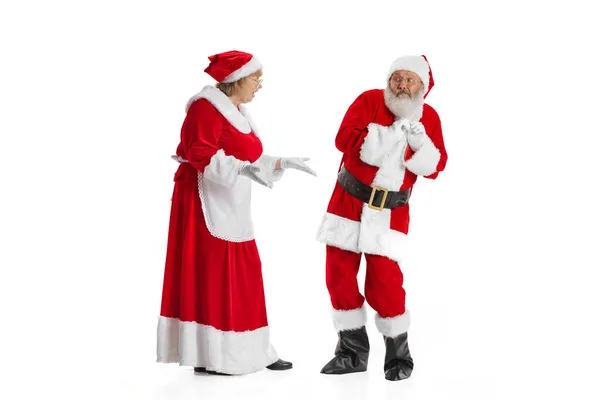 Portrait of cute woman and scared man, Santa Claus and missis Claus in traditional New Year costume isolated on white background. — Stock Photo, Image