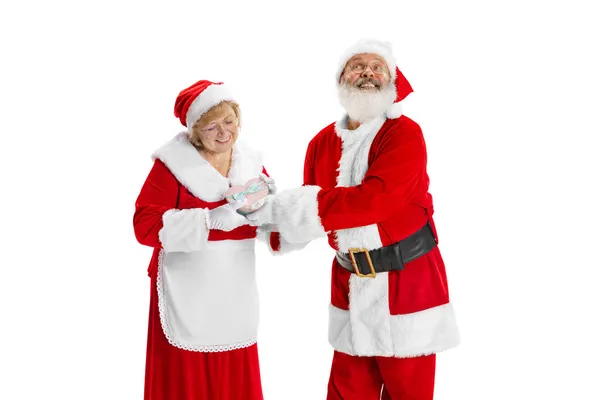 Щасливий усміхнений старий в костюмі Санта Клауса і мила жінка, пані Клаус з подарунковими коробками на білому фоні.. — стокове фото