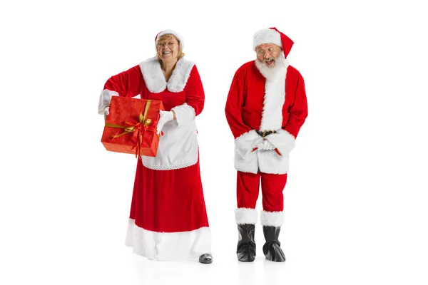 Happy smiling old man in Santa Claus costume and cute woman, missis Claus with gift boxes isolated on white background. — Stock Photo, Image