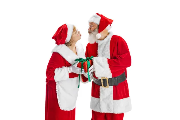 Glücklich lächelnder alter Mann im Weihnachtsmannkostüm und niedliche Frau, Missis Claus mit Geschenkschachteln isoliert auf weißem Hintergrund. — Stockfoto