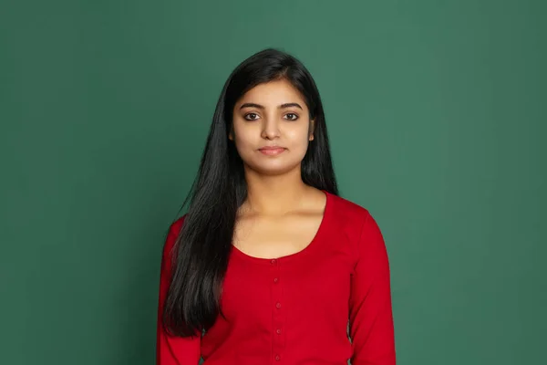 Meia-comprimento retrato de jovem bela menina sorridente, estudante olhando para a câmera isolada no escuro estúdio verde backgroud — Fotografia de Stock