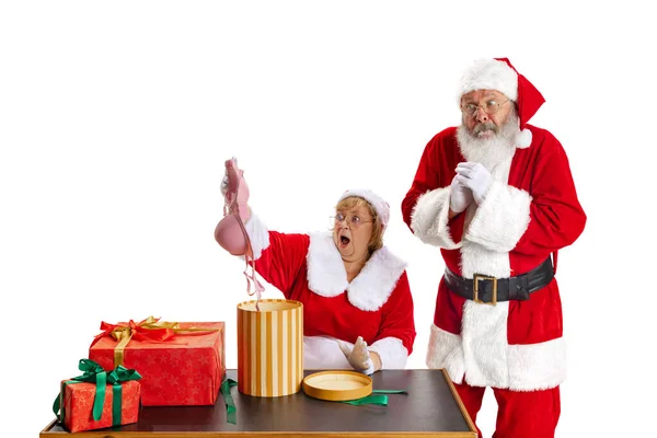 Aufgeregter Senior und schöne Frau mittleren Alters, Weihnachtsmann und Weihnachtsmann in traditioneller Neujahrstracht isoliert auf weißem Hintergrund. — Stockfoto