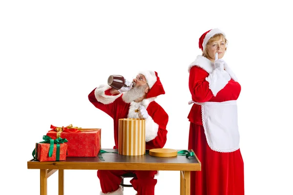Senior man en mooie vrouw van middelbare leeftijd, Santa Claus en mevrouw Claus in traditionele Nieuwjaar kostuum geïsoleerd op witte achtergrond. — Stockfoto