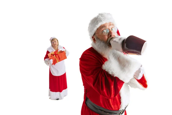 Glücklich lächelnder alter Mann im Weihnachtsmannkostüm und niedliche Frau, Missis Claus mit Geschenkschachteln isoliert auf weißem Hintergrund. — Stockfoto