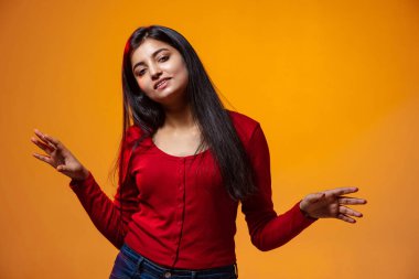 Genç, güzel, gülümseyen bir kızın yarım boy portresi sarı stüdyonun arka planında izole edilmiş öğrenci dansı.