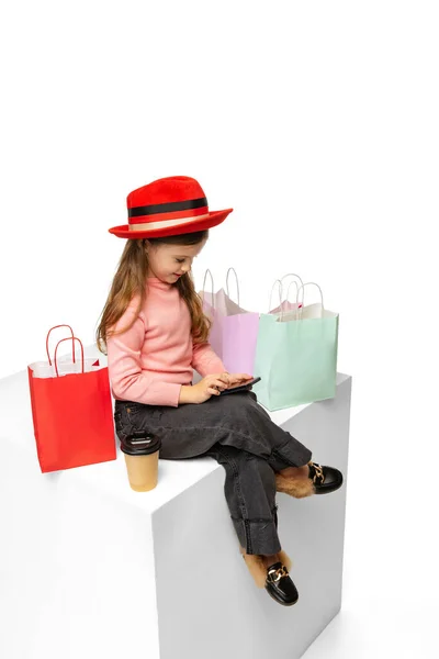 Πορτρέτο του κομψό όμορφο μικρό παιδί σε κόκκινο καπέλο κάθεται σε μεγάλο κουτί απομονώνονται σε λευκό φόντο. Ομορφιά, μόδα έννοια — Φωτογραφία Αρχείου