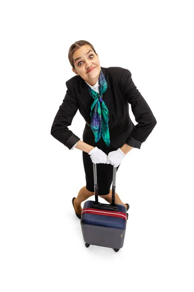 Wysoki kąt widzenia pięknej młodej dziewczyny, stewardessa w mundurze z walizką izolowane na białym tle studio. — Zdjęcie stockowe