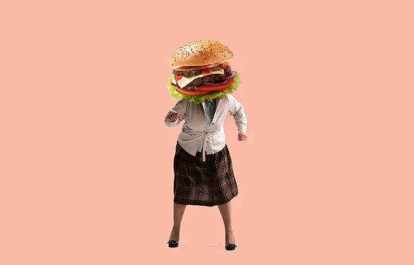 Collage d'art contemporain. Femme d'âge moyen en tenue des années 70, style mode des années 80 avec hamburger juteux au lieu de danser la tête isolée sur fond rose — Photo