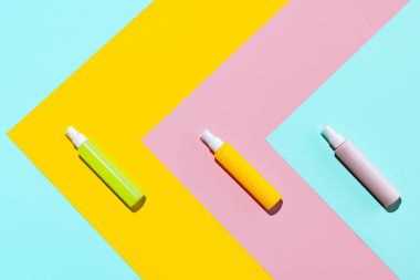 Üç renkli kavanoz, makyaj malzemeleri için sprey şişeleri, krem, losyon renkli arka planda izole edilmiş logolar olmadan..