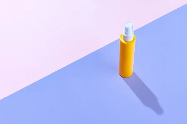 Vista superior de garrafas de spray amarelo para cosméticos, creme, loção sem logotipos isolados sobre fundo colorido. — Fotografia de Stock