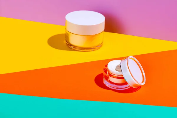 Parlak renkli arka planda markanız için kopyalama alanı olan yüz kozmetik kremi kavanozları. Model — Stok fotoğraf
