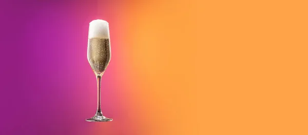 Szkło z zimnym szampanem z bąbelkami izolowane nad gradientowym fioletowym i pomarańczowym tle koloru w neonie. Pojęcie alkoholu, święta, Nowy Rok — Zdjęcie stockowe