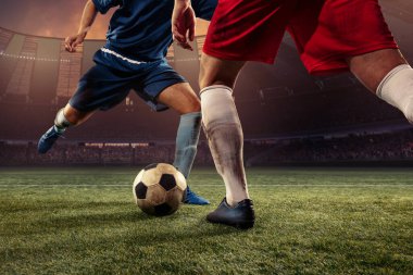İki erkek futbol oyuncusu, Crow Stadyumu 'ndaki maç sırasında stadyumda top sürüyor. Spor konsepti