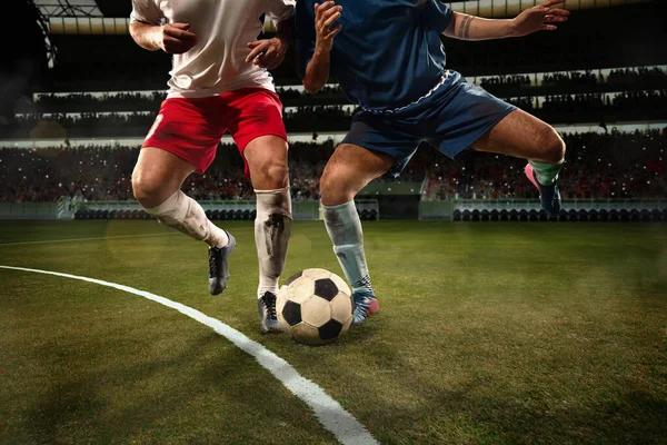 Two male soccer, football players dribbling ball at the stadium during sport match at crowed stadium. Sport concept — Stock Photo, Image