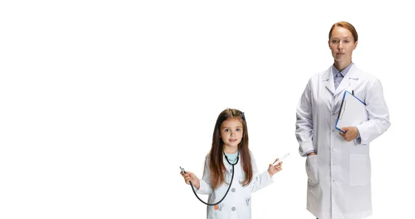 Portrait of cute beautiful little girl, child in image of nurse and female doctor posing isolated on white studio background — Stock Photo, Image