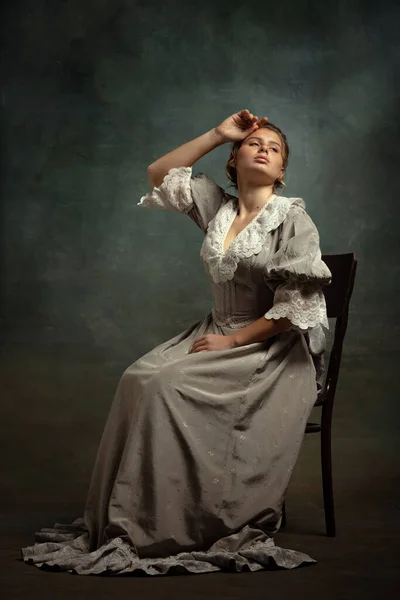 Retrato vintage de menina bonita jovem em vestido cinza de estilo medieval isolado no fundo escuro. Comparação de conceitos eras, estilo flamengo. — Fotografia de Stock