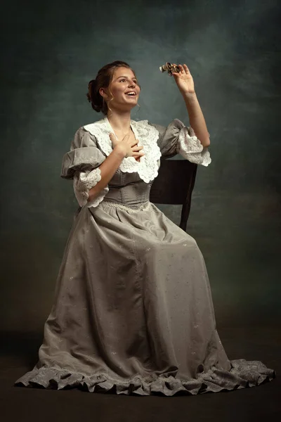 Retrato vintage de menina bonita jovem em vestido cinza de estilo medieval isolado no fundo escuro. — Fotografia de Stock