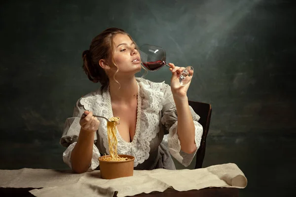 Retrato de media longitud de una joven hermosa en vestido gris de estilo medieval cenando aislada sobre fondo oscuro vintage. —  Fotos de Stock