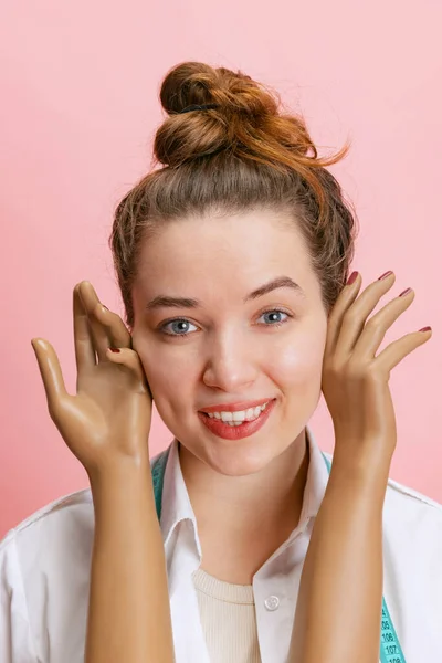 Retrato de cerca de la chica sonriente, costurera sastre sosteniendo maniquíes manos de plástico aisladas sobre fondo rosa. Concepto de trabajo, hobby —  Fotos de Stock