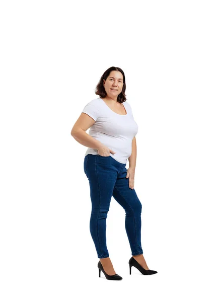 Beyaz stüdyo arka planında izole edilmiş beyaz tişört ve kot pantolon giyen iri yarı bir kadının tam boy portresi. Vücut pozitif konsept — Stok fotoğraf