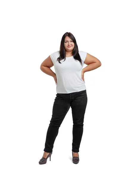 Retrato completo de mulher plus-size vestindo camiseta branca e jeans posando isolado no fundo do estúdio branco. Conceito de corpo positivo — Fotografia de Stock
